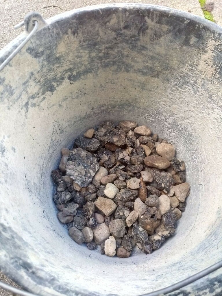 Bottom of a bucket full with chunks of dodgy roadworks.