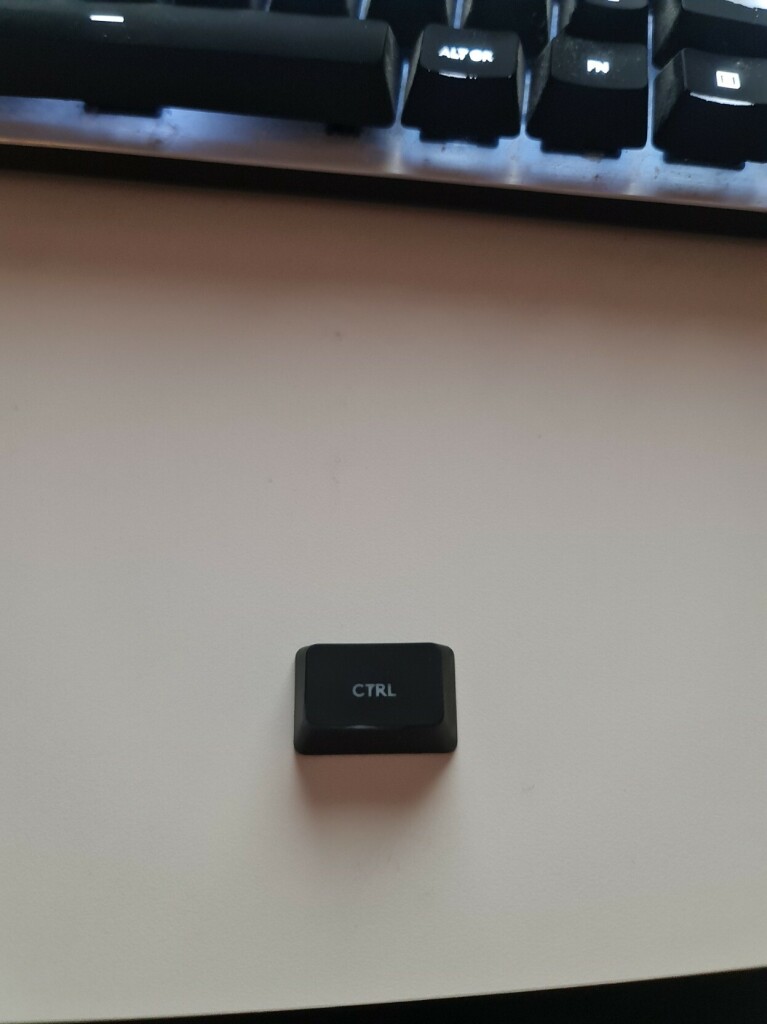 Ctrl keyboard button, loose, in front of a keyboard. 