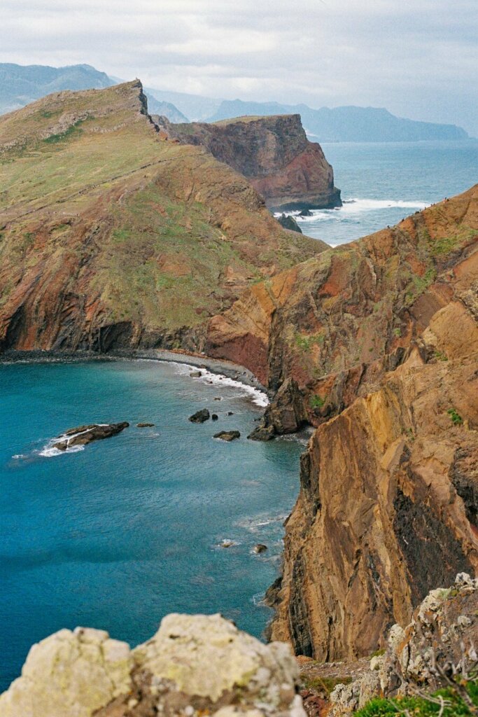 A photo of the cliffs with green slopes and the ocean visible on either side of the cliffs.