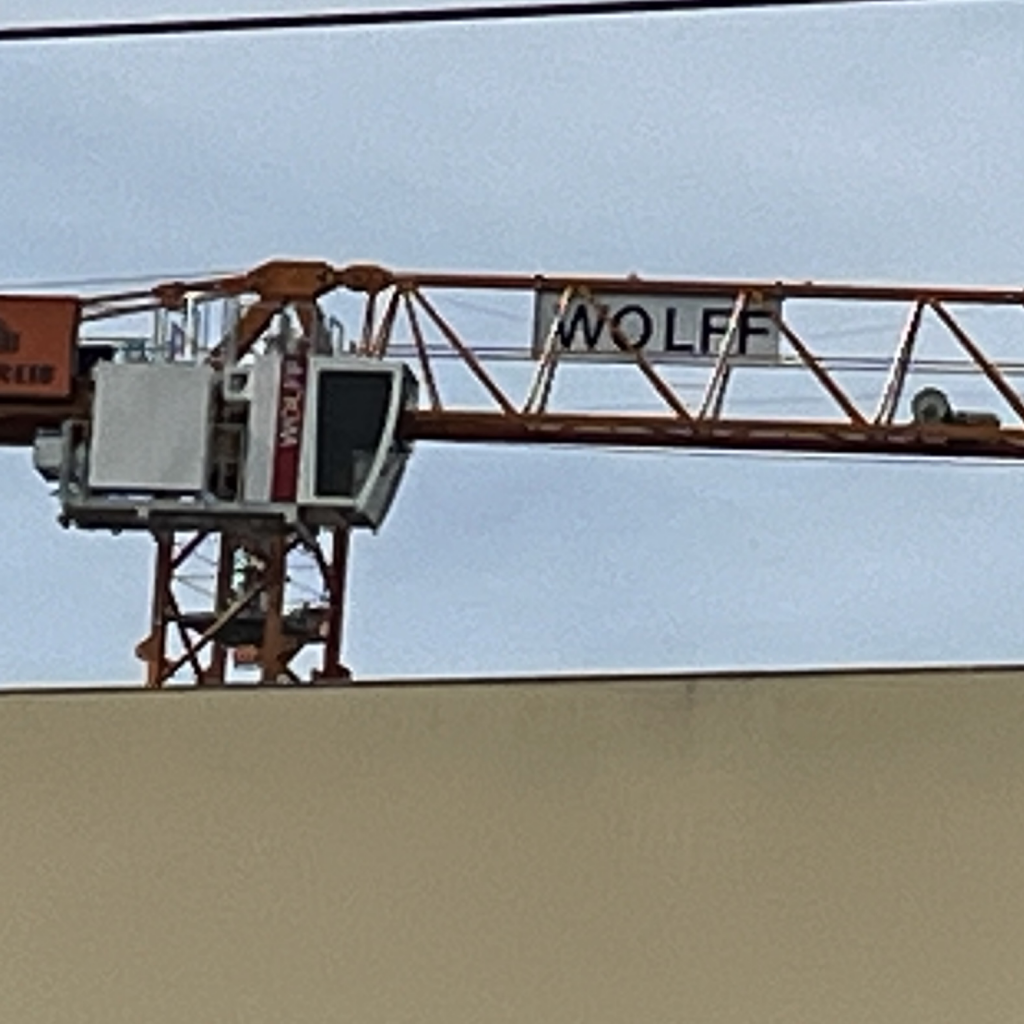 Tower crane with a sign that reads “Wolff”