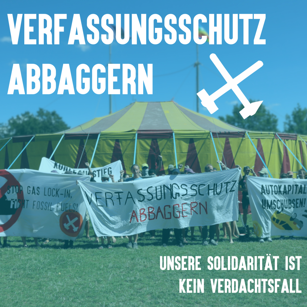 Auf dem Foto ist eine Menschenmenge zu sehen, welche vor einem großen Zirkuszelt steht. Die Menschen halten ein Transparent mit der Aufschrift „Verfassungsschutz abbaggern“. Auf weiteren Transparenten steht „Stop Gas Lock-In – Stop fossil fuels“ oder „Autokapitalismus umschubsen“. Die Bildüberschrift ist ebenfalls „Verfassungsschutz abbaggern“. Am unteren Bildrand steht „Unsere Solidarität ist kein Verdachtsfall“.

The photo shows a crowd of people standing in front of a large circus tent. The people are holding a banner with the inscription "Verfassungsschutz abbaggern". Other banners read "Stop Gas Lock-In - Stop fossil fuels" or "Push around car capitalism". The caption is also "Dredge up the Office for the Protection of the Constitution". At the bottom of the picture it says "Our solidarity is not a suspicious case".