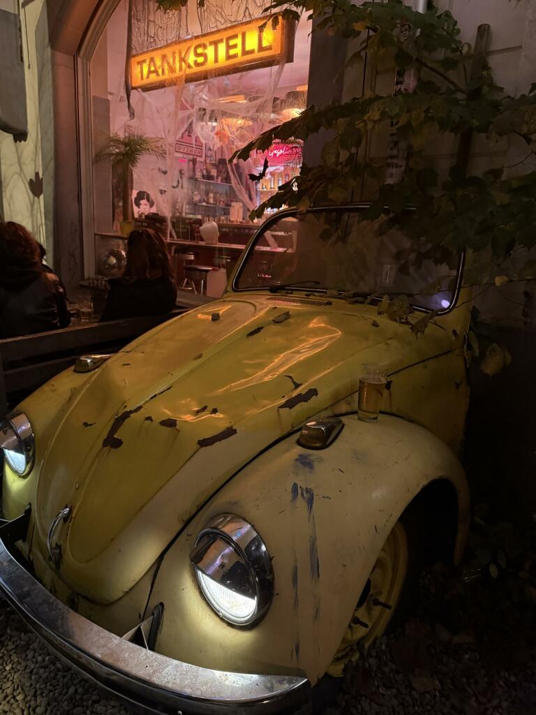 am abend- einenverbeulte vw käfer-front vor einer kleinen bar