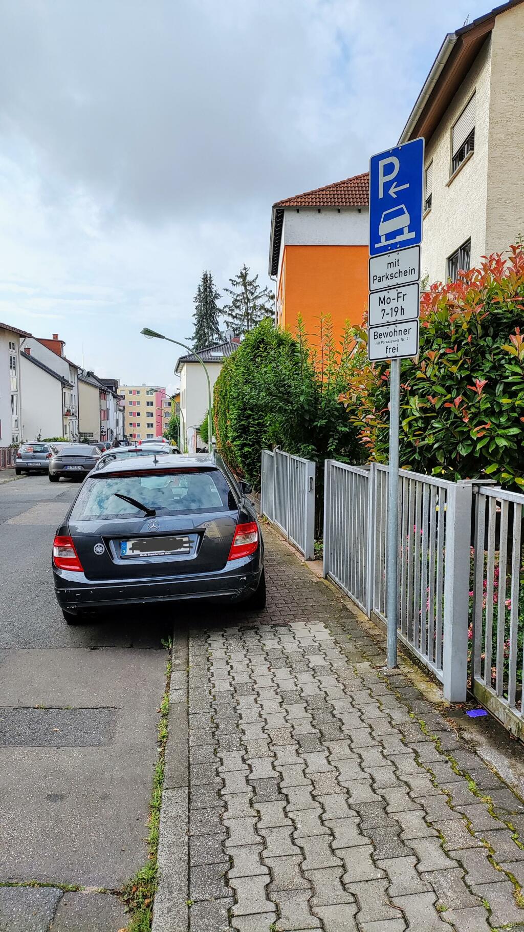 Auto parkt auf dem Bürgersteig. Da ist Gehwegparken erlaubt, weil rechts im Bild ein Schild (zeichen 315 steht ) obwohl nur noch 50 cm rest gehwegbreite übrig ist. 