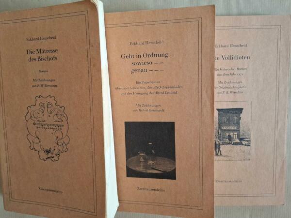 die drei Bände der Trilogie des laufenden Schwachsinns von Eckhard Henscheid 
von links nach rechts 
Die Mätresse des Bischofs 
Geht in Ordnung – sowieso – – genau – – – 
Die Vollidioten 