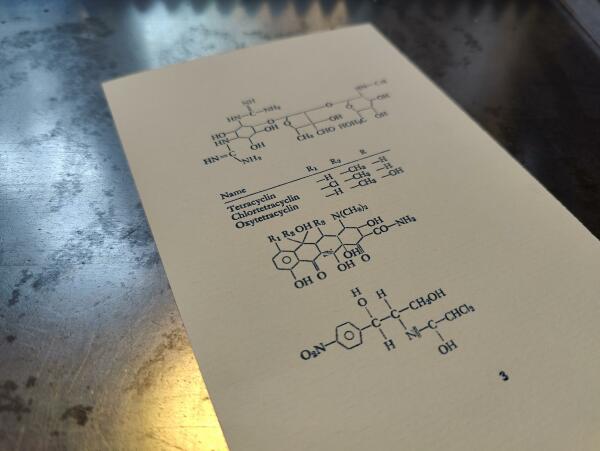 Foto des Abzugs der Form auf Vorsatzpapier. Der Bleisatz besteht aus chemischen Formeln.