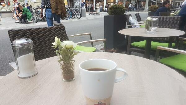 Becher Kaffee draußen vorm Café 