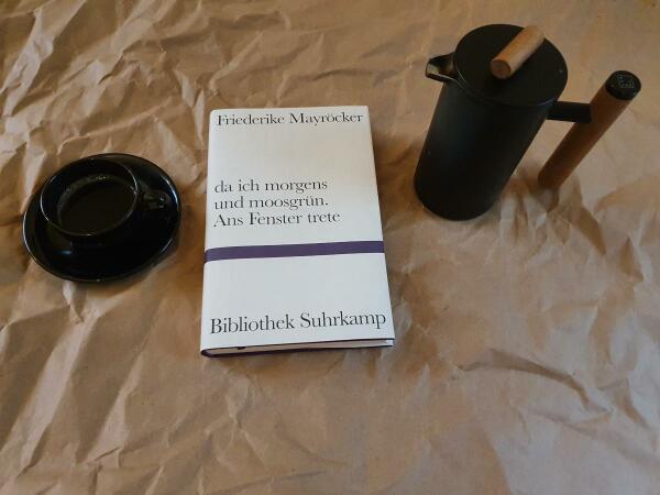 Tasse Espresso, Buch von Friederike Mayröcker und Preßkanne auf Packpapier 