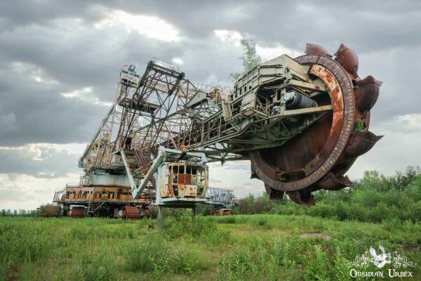 large machine, rusting. It has a rotating bucket at the front
