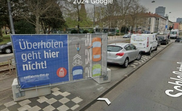 Screenshot aus Google Streetview zeigt großes Banner neben einer Fahrbahn in der Stadt Frankfurt:
"Überholen geht hier nicht!"