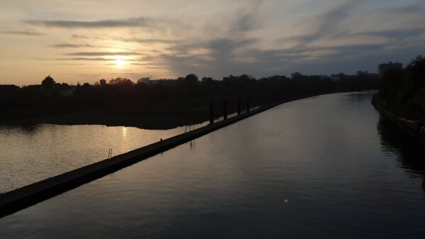 Blick vom Wehr über den Neckar auf Wieblingen mit tiefstehender Sonne