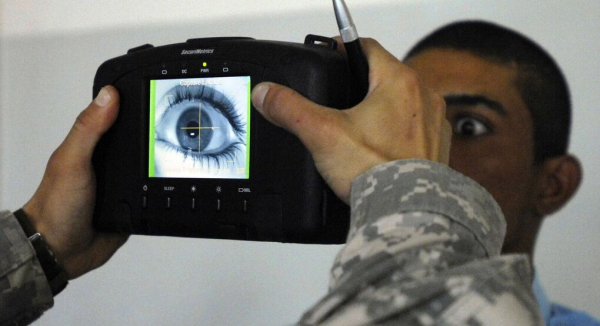 Iris-Scan durch US-Militär im Irak.

zu sehen ist der  halbe Kopf eines Mannes von einer Kamera verdeckt welche sein Auge ablichtet. 