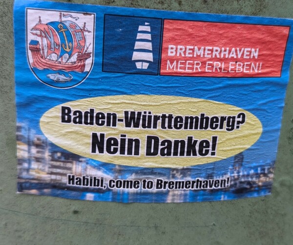 Aufkleber: "Baden-Württemberg? Nein Danke!" Im gelben Oval 

Darunter der Text: "Habibi, come to Bremerhaven"

Hintergrund ist ein Aufkleber vom Stadtmarketing mit Hafen, Stadtwappen und dem Text Bremerhaven Meer erleben